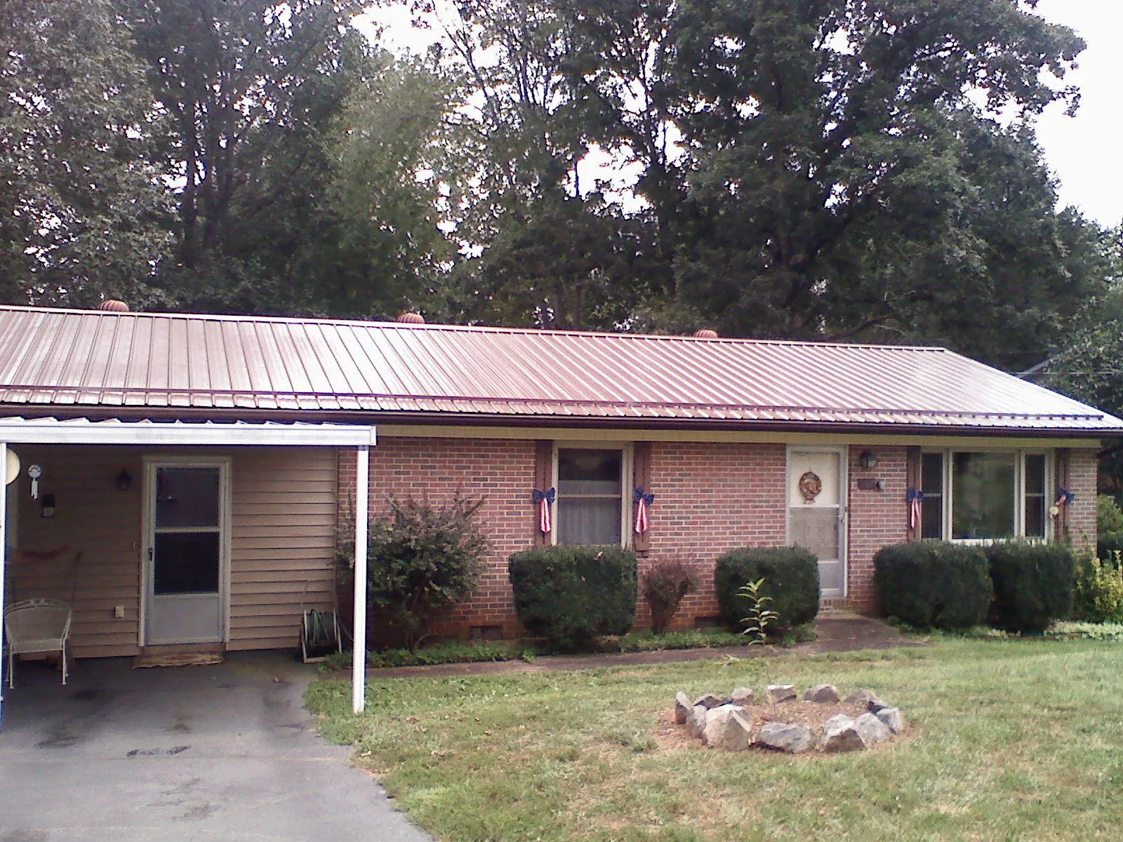 Bronze metal roof and carport on a brick ranch home — Roof Repair work by our crew in Buchanan